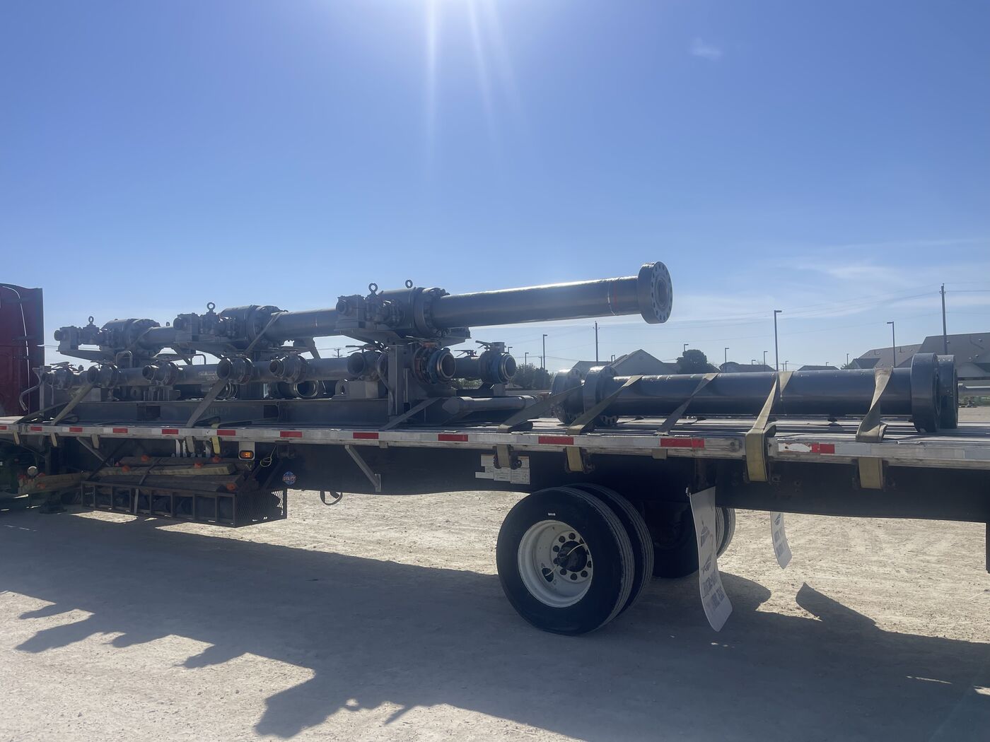 Oilfield wellhead valve assemblies and completion equipment secured on flatbed trailer
